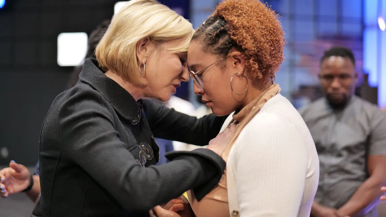 Paula White praying for woman during Paula White Ministries service